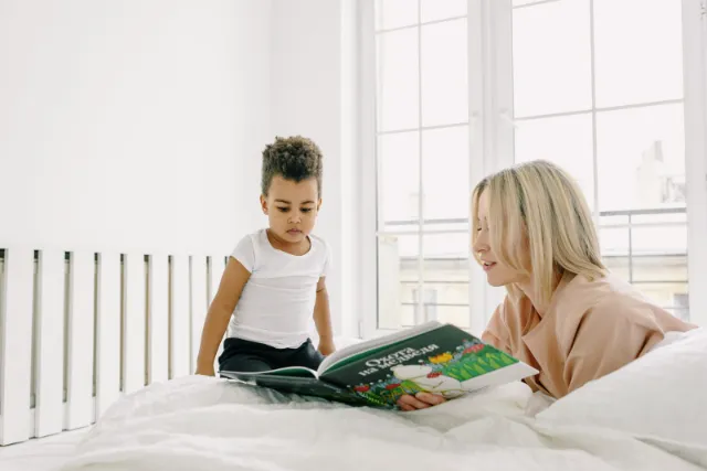 A parent and child reading a picture book together